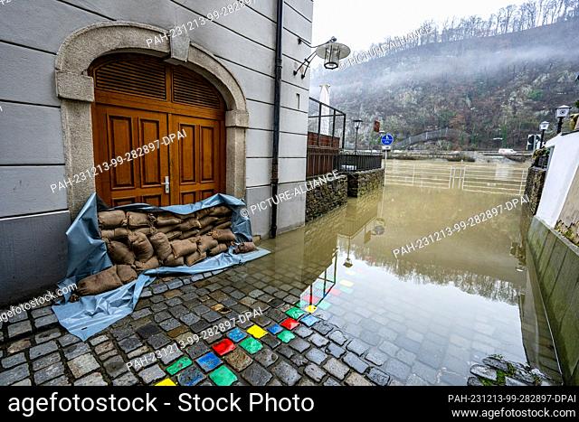 13 December 2023, Bavaria, Passau: Sandbags lie in front of an entrance to a house on the banks of the Danube. The flood situation remains tense in parts of...