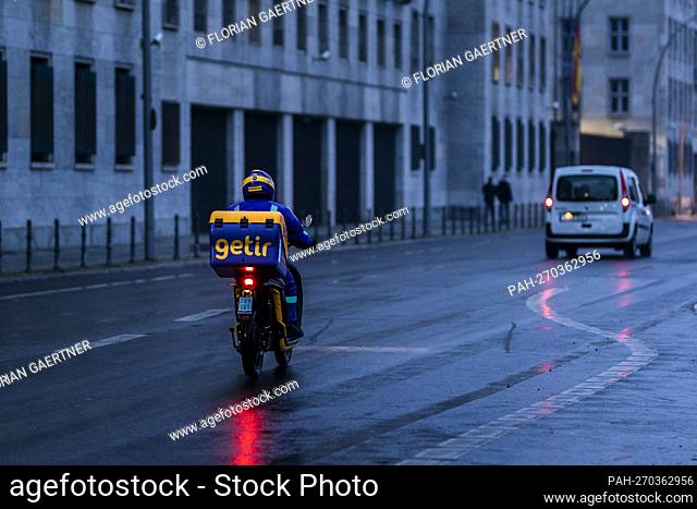 An employee from the Getir delivery service drives along Wilhemstrasse in the evening in Berlin, January 10th, 2022. Copyright: Florian Gaertner / photothek