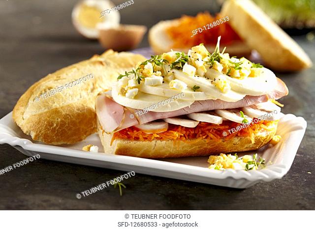 A sandwich with carrot, mushrooms, boiled ham, mozzarella, egg and cress