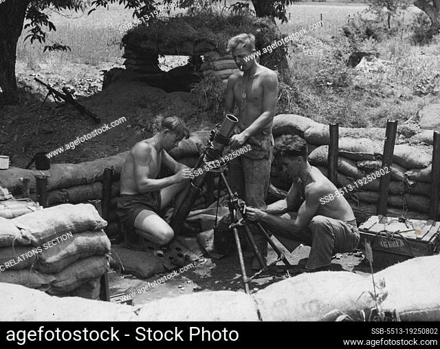 In their sandbagged pit on a forward position South of a river a mortar crew of 3 Bn., The Royal Australian Regiment are seen busily cleaning their mortar