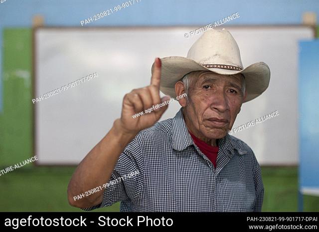 20 August 2023, Guatemala, Guatemala-Stadt: Luis Escalante, a resident of Santa Cruz, shows his finger stained with election ink after casting his vote in the...