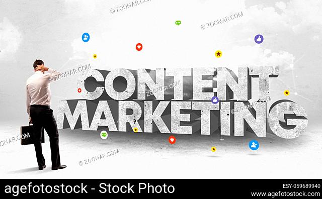 Young businessman standing in front of CONTENT MARKETING inscription, social media concept