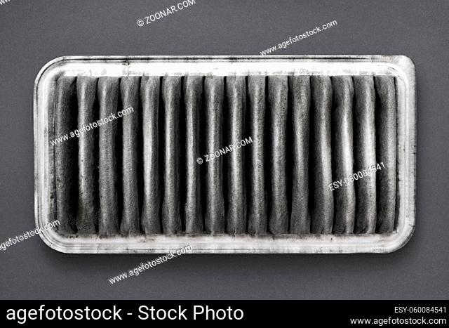 detailed fragment of dirty air filter on gray background