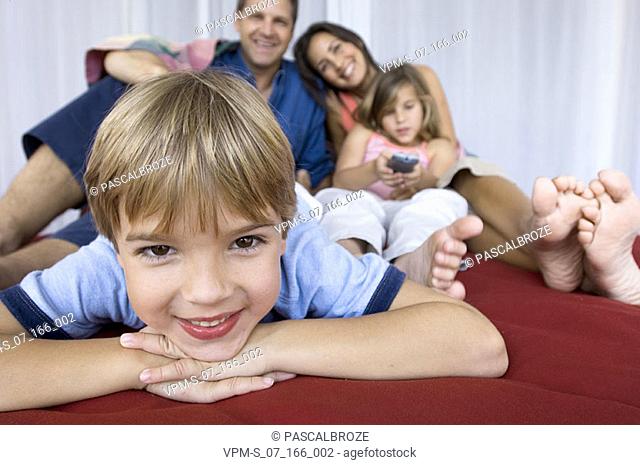 Portrait of a boy with his parents and his sister behind him