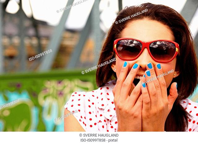 Teenage girl in sunglasses, looking shocked