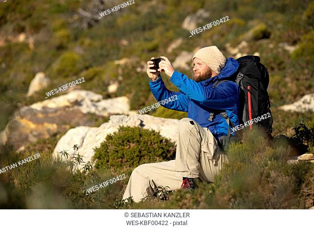 Spain, Andalusia, Tarifa, man on a hiking trip sitting down taking a selfie