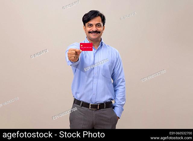 Man in formal outfit displaying credit card