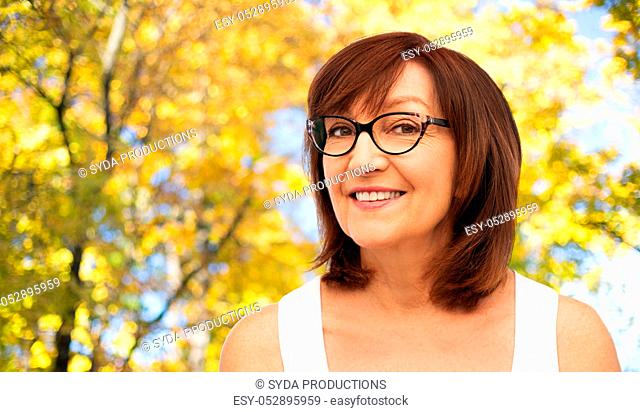 portrait of senior woman in glasses in autumn