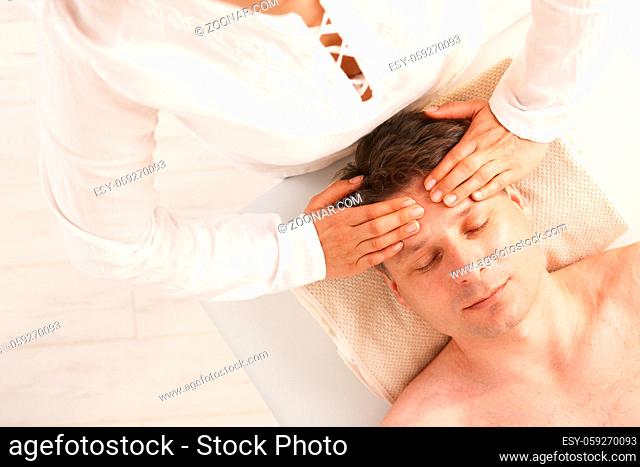 Man getting relaxing head massage in dayspa