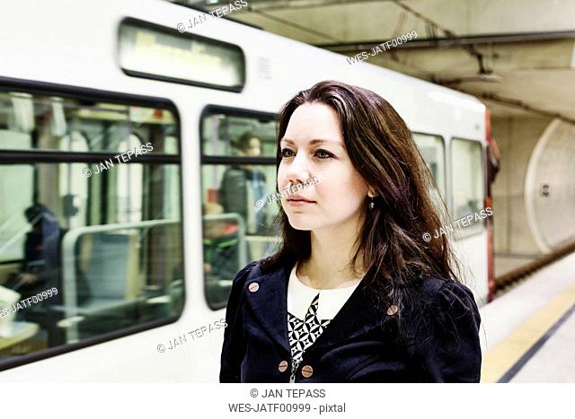Germany, Cologne, portrait of young woman waiting at underground station platform