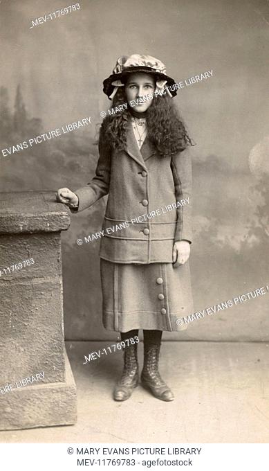 Studio portrait, girl in suit and hat, with long frizzy hair