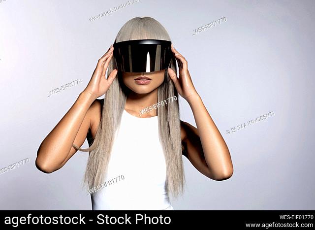 Woman wearing futuristic visor glasses against white background