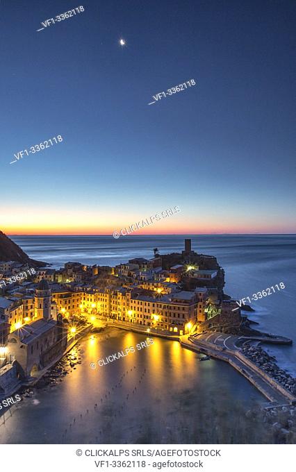 A moonlit night leaving the scene to the first lights of the sunrise over the pictoresque village of Vernazza and its harbor