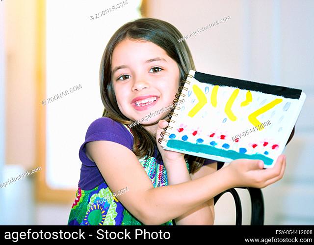 Portrait of a beautiful girl showing her drawing