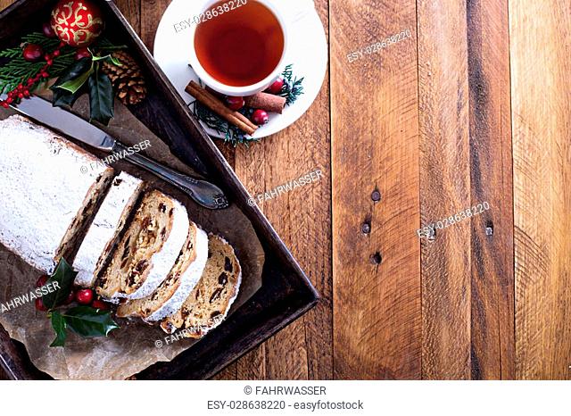Christmas stollen with dried fruits and marzipan served with tea and decorations