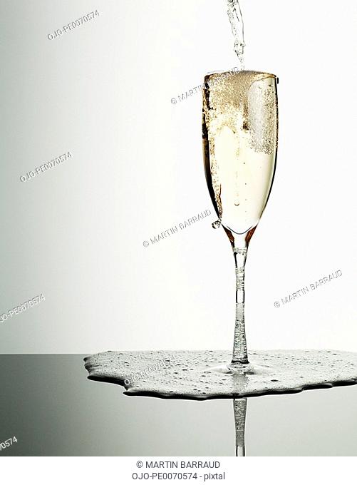 Champagne pouring into glass and overflowing