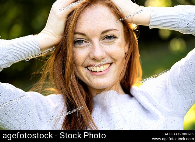 Portrait of smiling young woman in park