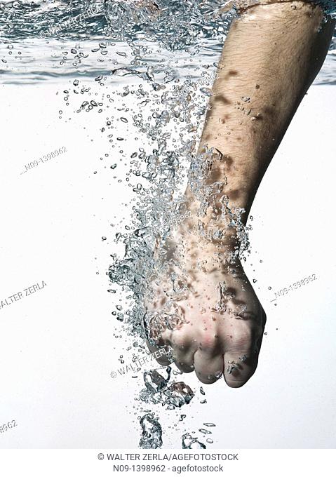 Male fist enters in pure water