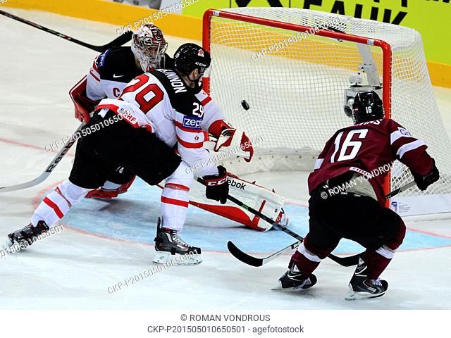Kaspars Daugavins, of Latvia, right, shoots to score past Canada's goalkeeper Mike Smith, left, and Nathan Mackinnon of Canada, center