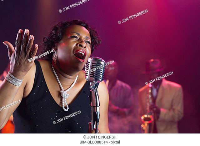 Black woman singing on stage with jazz band