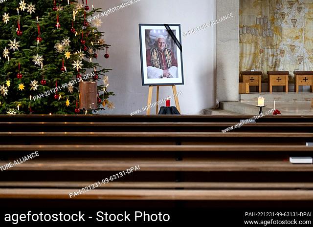 31 December 2022, Bavaria, Marktl: A picture of Pope Emeritus Benedict XVI stands in the church of St. Oswald. Pope Emeritus Benedict XVI died Dec