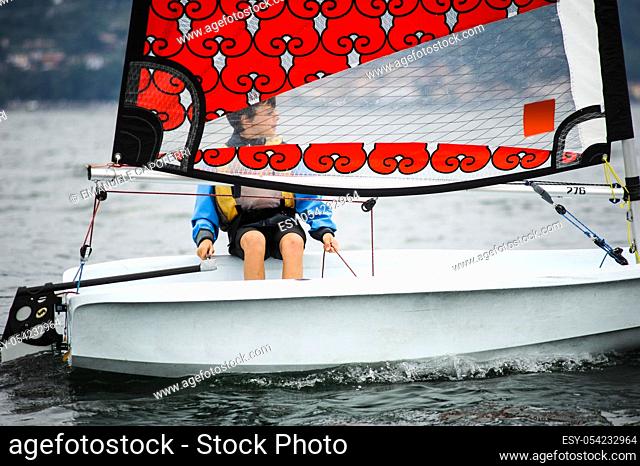 Child sailing on sailboat in the waters of Lake Maggiore, Ispra, Varese, Lombardy, Italy