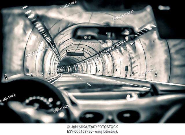 Abstract toned photo of a car driving through highway tunnel