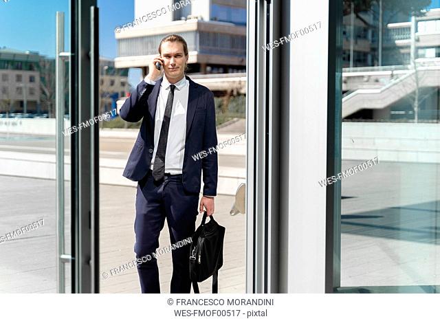 Italy, Florence, young businessman on smartphone outdoor