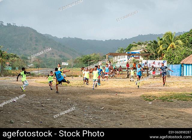 Capurgana, Colombia - march 2018: Children playing soccer on the street in village center of Capurgana, Colombia