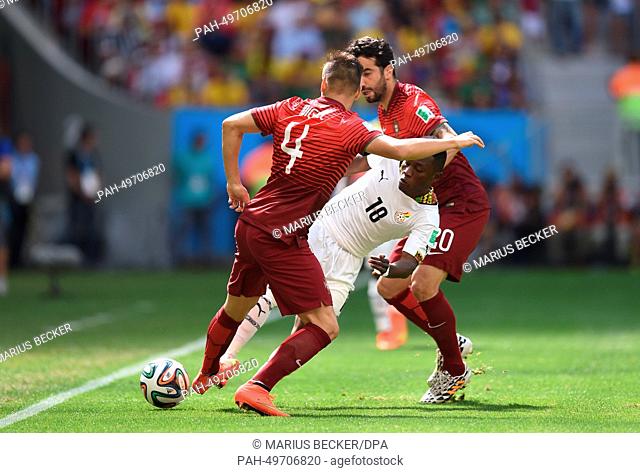 Majeed Waris (C) of Ghana in action against Miguel Veloso (L) and Ruben Amorim of Portugal during the FIFA World Cup 2014 group G preliminary round match...