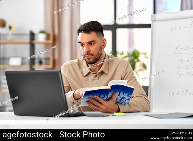 math teacher with laptop and book at home office