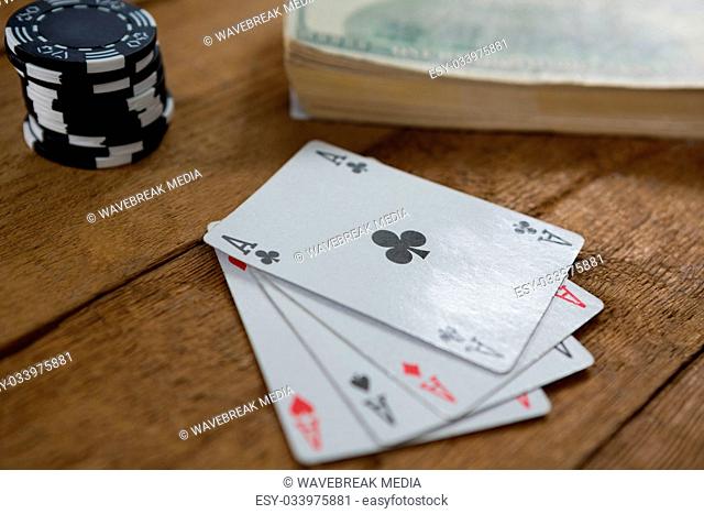 Close-up of four aces by chips and money
