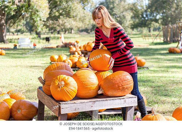 30 Year old redheaded woman with pumpkins in autumn