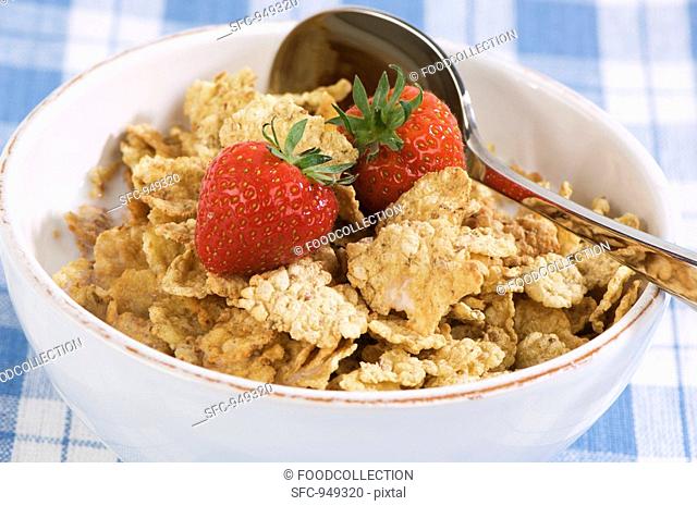 Bowl of wholemeal cornflakes and fresh strawberries