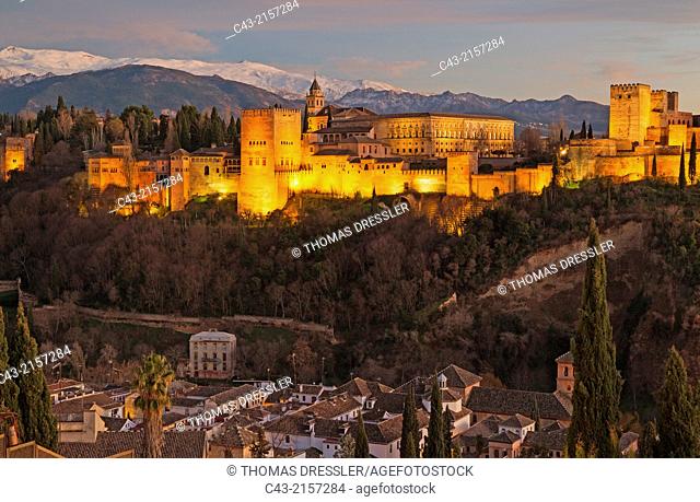 The magnificent Alhambra palace, illuminated at dusk. On the right the Alcazaba (Moorish castle). In the foreground the Albaicín