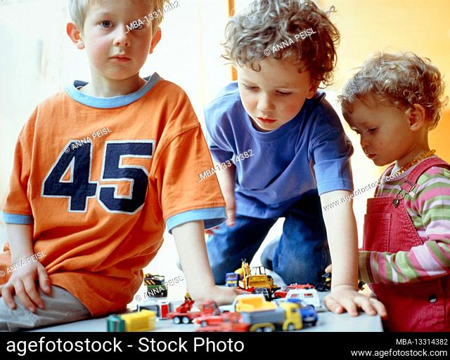 3 children play with toy cars