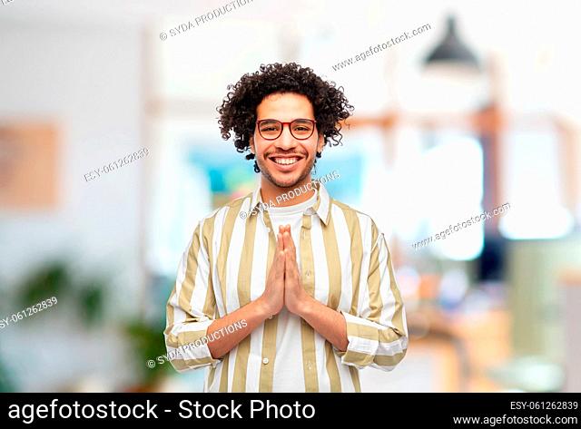 happy man in making namaste gesture at office