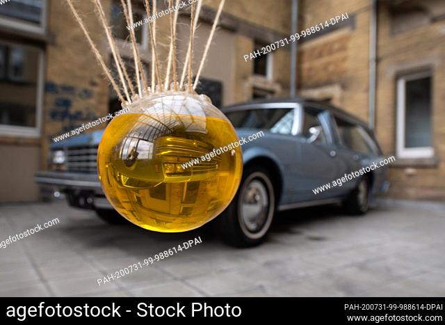 24 July 2020, Hessen, Kassel: The object ""Brain in Oil"" in front of a Chevrolet Impala as hearse in the Museum of Cultural History for Sepulchral Culture