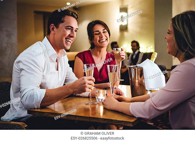 Group of friends enjoying a bottle of champagne in a restaurant