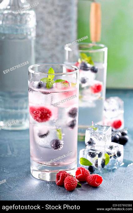 Sparkling water with berry and mint ice cubes