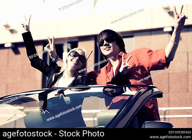 Happy young couple in a convertible car