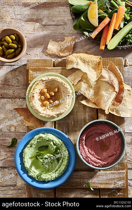Red, green and yellow hummus with flatbread