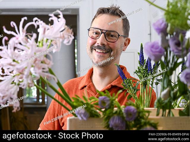 22 August 2023, Berlin: Florist Nicolaus Peters stands behind flowers from which he ties a bouquet. He is taking part for Germany in the World Cup of Florists...
