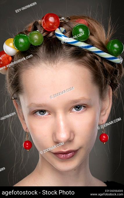 Portrait of a funny teenage girl with a wreath of sweets on her head