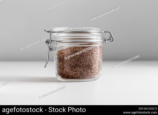 close up of jar with flax seeds on white table