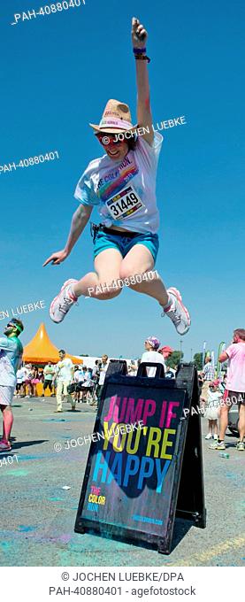 A participant in the Color Run jumps after the race in Hanover, Germany, 07 July 2013. Several thousand participants took part in a 5 km run during which tehy...
