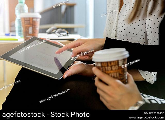 Germany, Bavaria, Munich, Close up of young women using together digital tablet