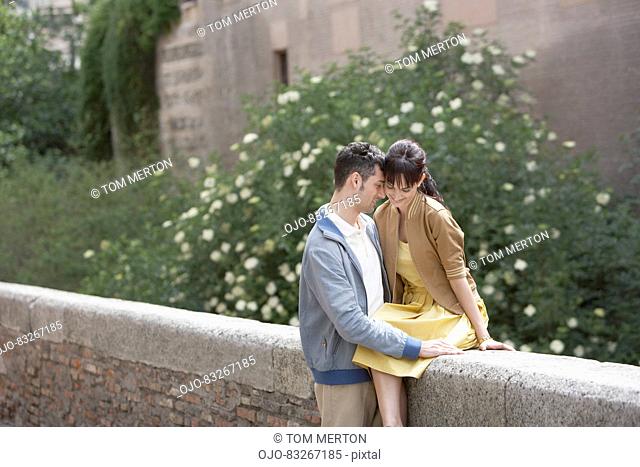 Couple hugging on stone wall