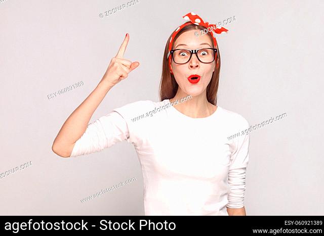 wow. I have an idea. portrait of beautiful emotional young woman in white t-shirt with freckles, black glasses, red lips and head band