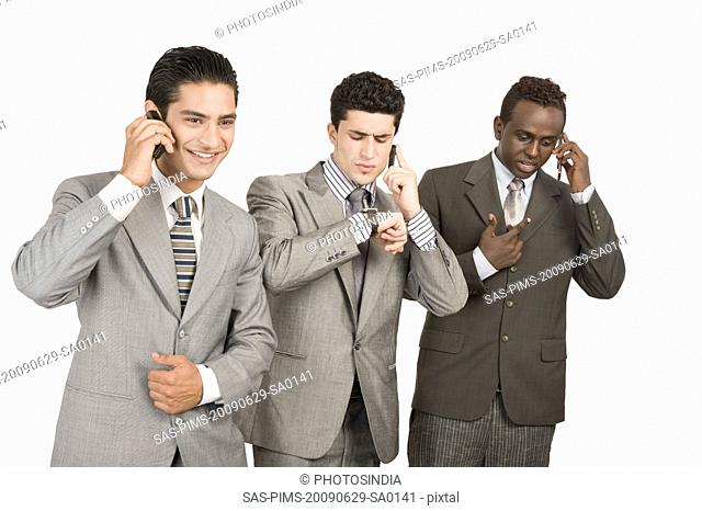 Three businessmen talking on mobile phones
